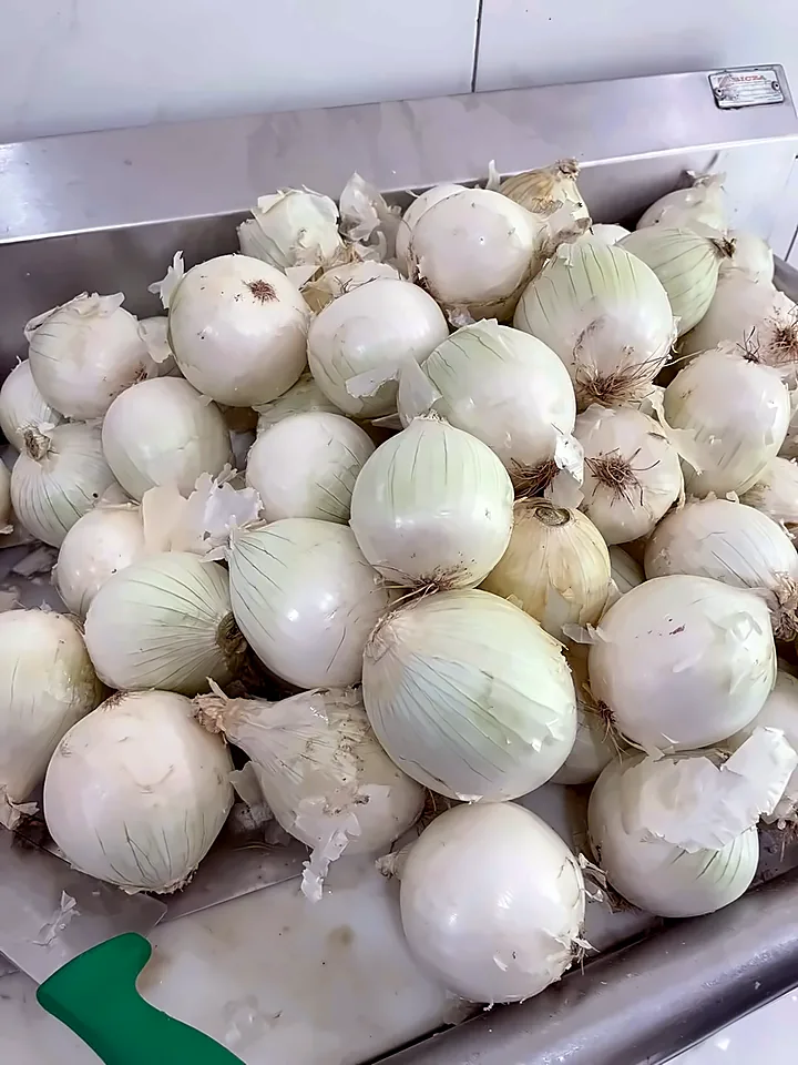 Cebolla blanca entera sobre la mesa de acero